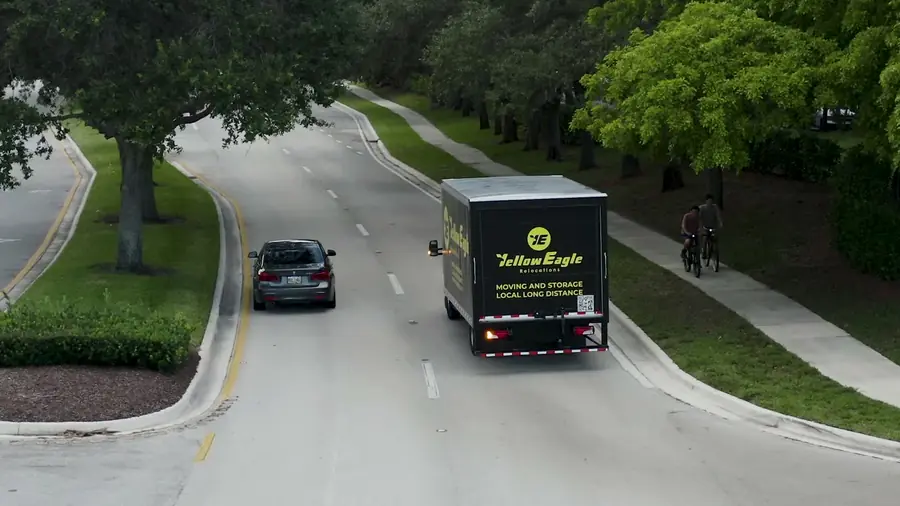 A Yellow Eagle tractor and trailer seen from above, traveling a divided highway