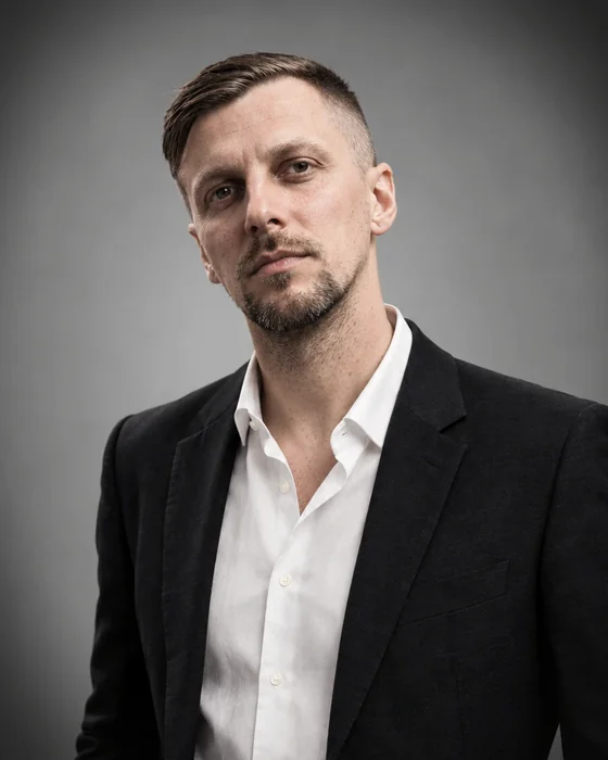 Illia Shymanchyk, head and shoulders, in a dark jacket and open collar